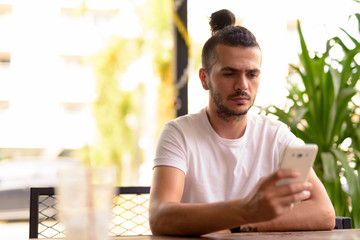 Handsome Turkish man with curly hair relaxing at the coffee shop