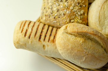 Various types of bread served on a wicker tray, delicious and fresh rolls