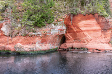 Beautiful red sandstone cliff in wild river in Līgatne Gaujas National Park in Latvia