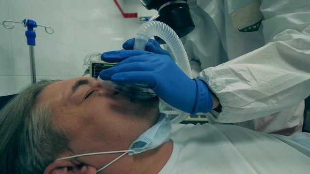 A physician uses ventilator on a patient with respiratory problems.
