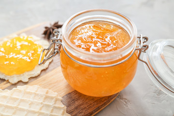 Jar of orange jam with wafers on table