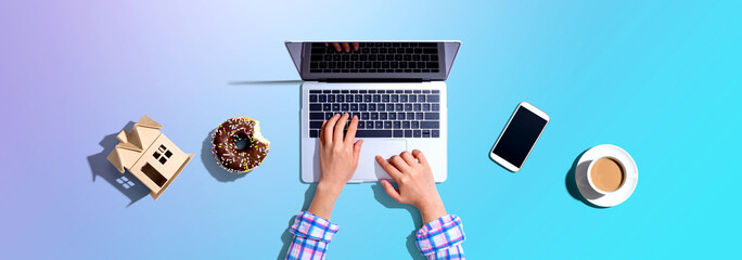 Woman using a laptop computer with a donut and a cup of coffee