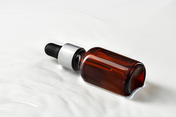 Skincare serum bottle on a light beige background close up