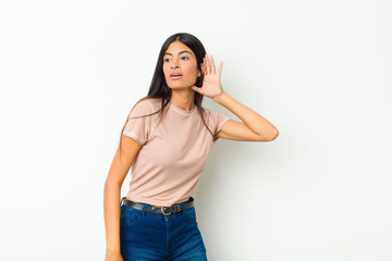 young pretty latin woman looking serious and curious, listening, trying to hear a secret...