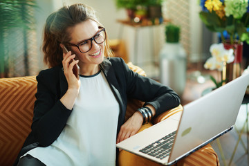 happy modern woman with laptop speaking on cell phone