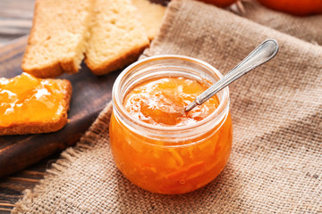 Jar of orange jam on table