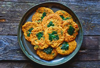 Healthy spicy vegan Indian style chickpea pancakes with vegetables and parsley in a plate Top view