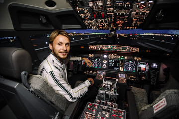 Guy enjoying time in avia simulator. Real cockpit of Boeing aircraft. Night time shot