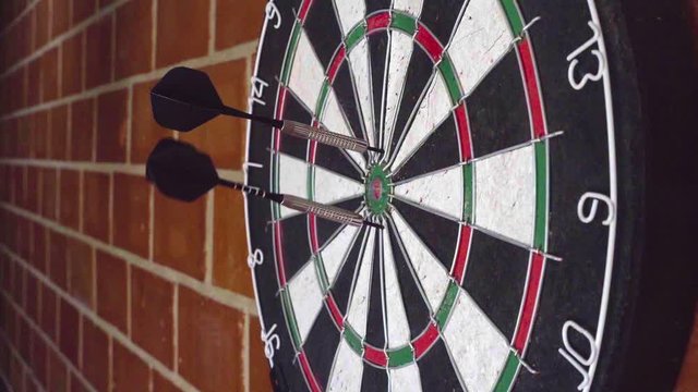 Throw 3 darts at the darts board. slow motion