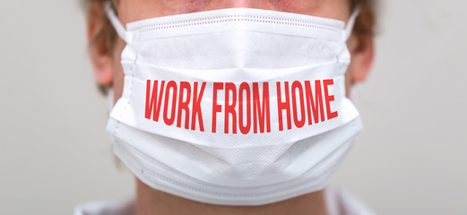 Work From Home theme with person wearing a protective surgical face mask