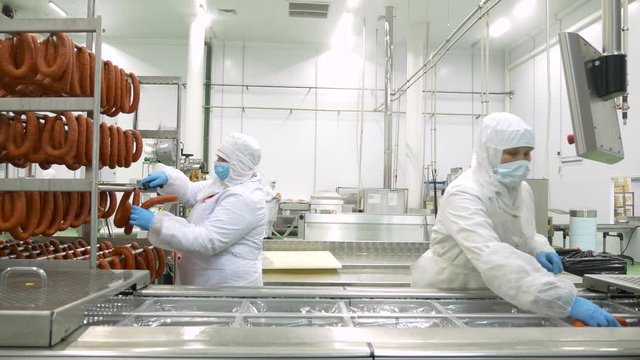 Factory workers make sausage meat processing plant