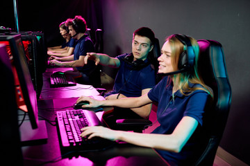 Young cyber sport gamer giving advice to girl in headphones while they preparing for e-sport competition © pressmaster