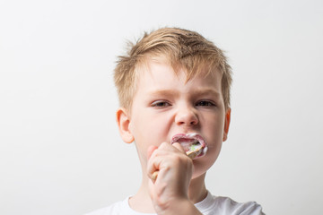 cute boy posing with bamboo toothbrush in his mouth, child brushes his teeth