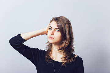 Woman with hand on head, straightens the hair