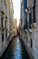 Fototapeta na wymiar Old narrow canal with parked boats quiet streets of Venice at summer morning. Traveling concept background, Italy