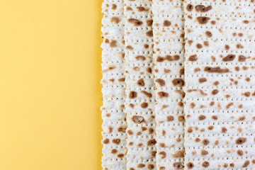 Matzo. Traditional jewish easter bread. Passover holiday symbol. On a yellow background. With some free space for your text or sign. Close-up.