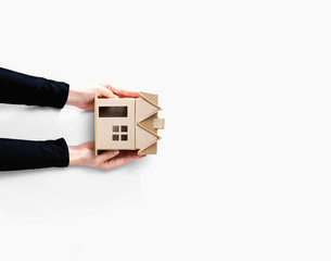 Woman holding a cardboard house overhead view