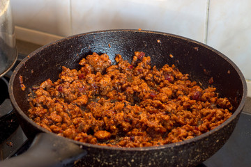 The process of cooking macaroni with minced meat and tomato sauce