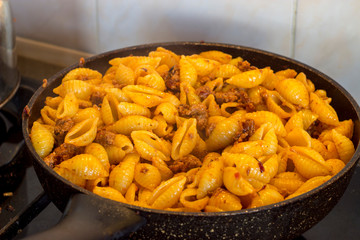 The process of cooking macaroni with minced meat and tomato sauce