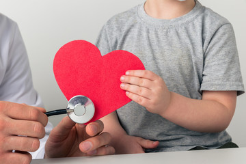 Man and kid are listening to the heart by stethoscope. Support your health concept