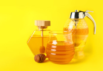Glassware of sweet honey on color background