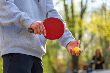 Tischtennis spielen im Freien: Jugendliche macht eine Angabe im Park / im Grünen