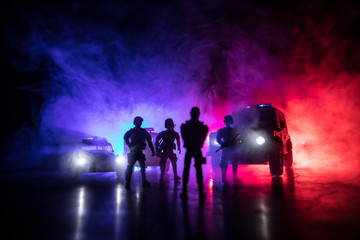Fototapeta na wymiar Police cars at night. Police car chasing a car at night with fog background. 911 Emergency response police car speeding to scene of crime. Selective focus