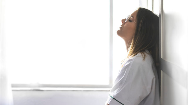 Female doctor standing by wall