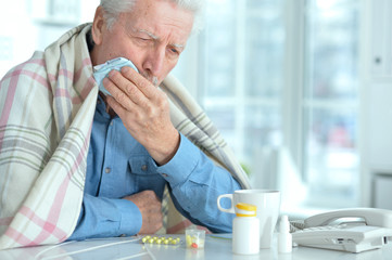 Portrait of sad sick senior man with medicine