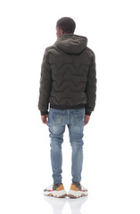 casual guy in black jacket looking at white wall