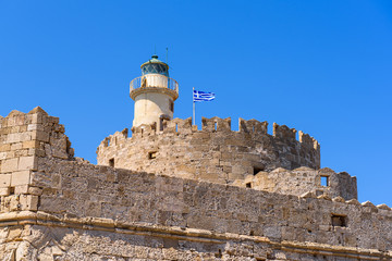 The tower with lighhouse of St. Nicholas fort in Mandraki port of Rhodes. Greece