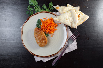 Dishes from cutlets with and Korean carrots on a plate.