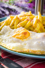Fried egg served with boiled potatoes and yellow beans.