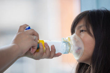 Mexican little girl with respiratory failure due to coronavirus pandemic using inhaler