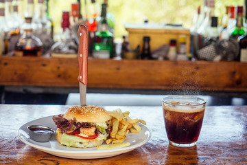 burger with prawns and drink on glass in tropical bar near beach