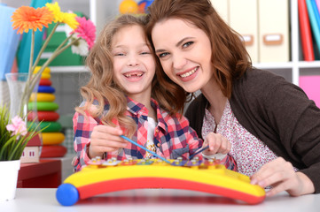 Portrait of cute little girl and her mother playing