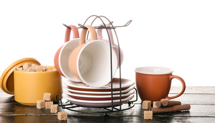 Holder with cups and saucers on table against white background