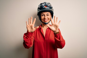 Middle age motorcyclist woman wearing motorcycle helmet over isolated white background showing and pointing up with fingers number ten while smiling confident and happy.