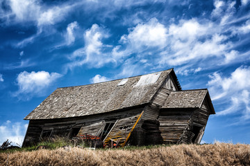 An old dilapidated schools house under blue skies