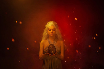 Art photo Portrait young beautiful woman blond hair in fire ash stained face. Fantasy power queen...