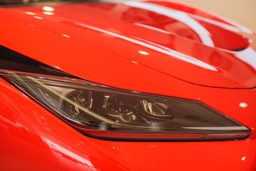Predatory car headlight and hood of powerful sports car with matte paint.