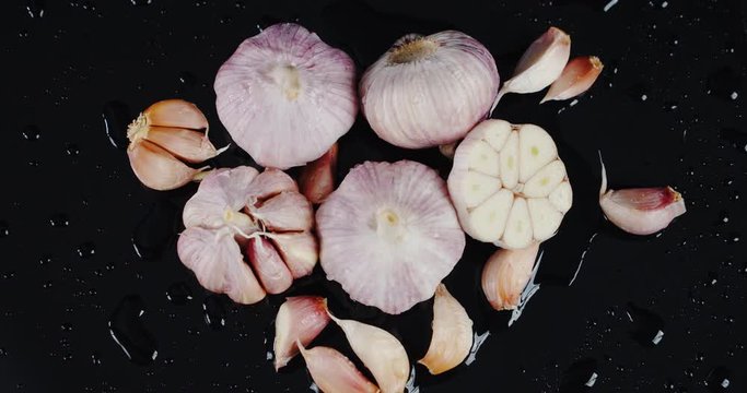 Cloves and heads of garlic slowly rotate.