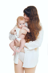young brunette mom with long hair and a white shirt holds a newborn son. A 4 month old baby in her arms. Isolate