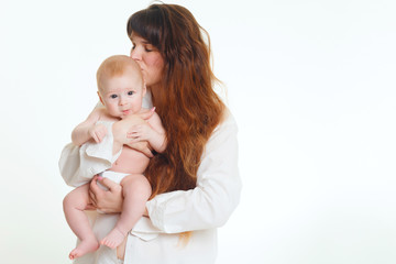young brunette mom with long hair and a white shirt holds a newborn son. A 4 month old baby in her arms. Isolate