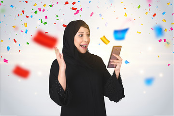 Excited young Arab woman amazed by unbelievable shopping mobile app sale message looking at...