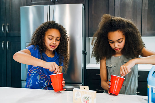 Girls making homemade slime in home kitchen