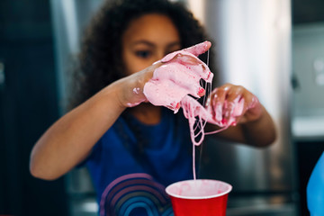 Girl making homemade slime in home kitchen