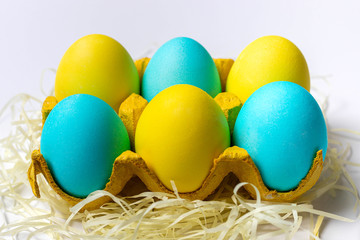 Fototapeta na wymiar Easter eggs in yellow paper egg tray isolated on white background. Close-up