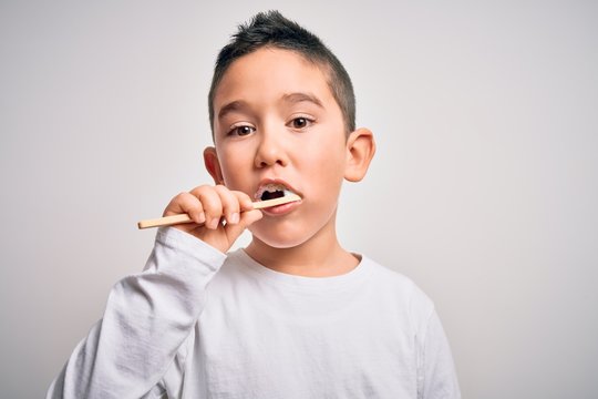 Young little kid boy brushing her teeth using tooth brush and oral paste, cleaning teeth and tongue as healthy health care morning routine. Learning dental education