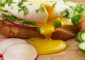 sandwich on toasted white slice of bread with poached eggs, dill and with slices of green onions
